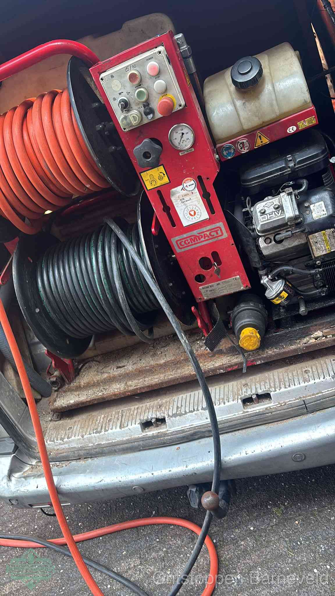 Een rood hogedruk-rioolreinigingstoestel in de laadbak van de bedrijfsbus, apparatuur voor een hardnekkige afvoerverstopping in Barneveld