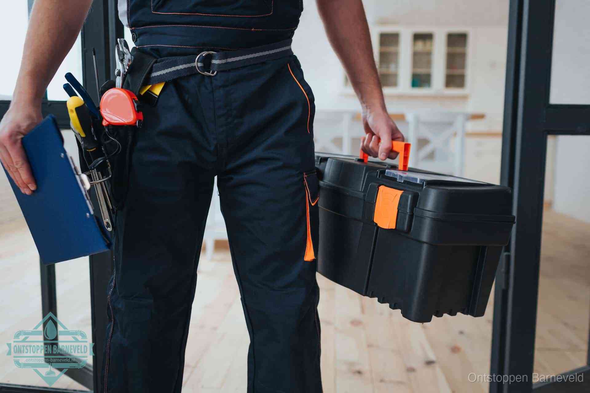 Een monteur met gereedschapsriem en klembord, klaar om een transparante prijs voor het wc ontstoppen in Barneveld te geven