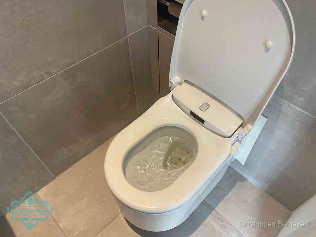 Een toiletpot vol troebel water met drijvend papier en restanten, de meest voorkomende oorzaak van een verstopte wc in Barneveld