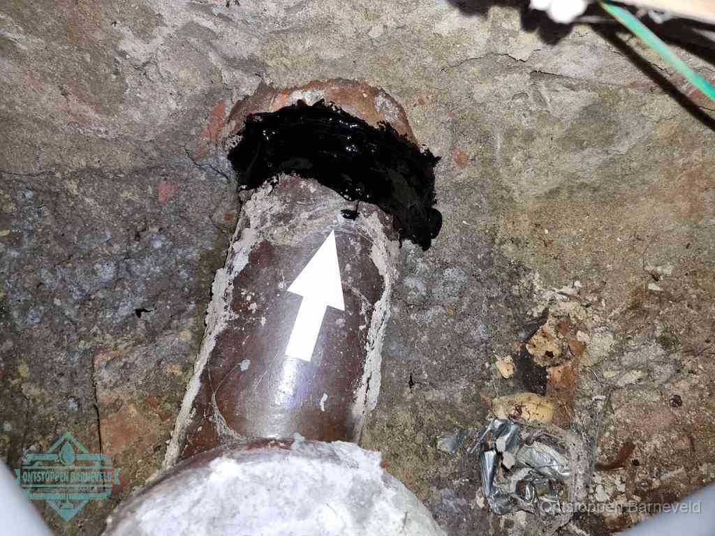 Een oude gres rioolbuis met een beschadigde koppeling onder de vloer, oorzaak van terugkerende structurele wc-problemen in Barneveld