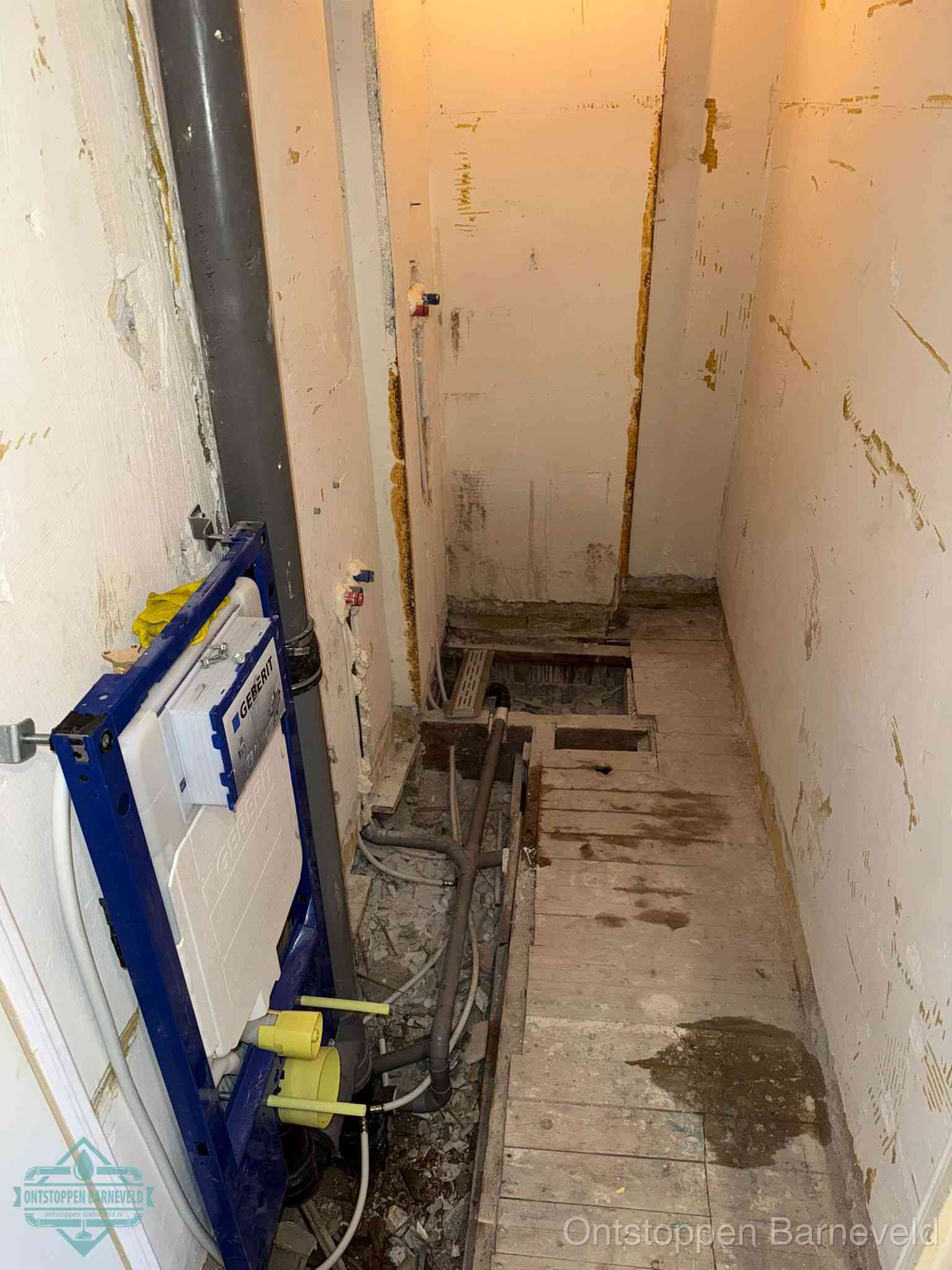 Een opgebroken toiletruimte tijdens renovatie met een Geberit inbouwreservoir en blootliggende oude afvoerleidingen, typisch voor oudere woningen in Barneveld